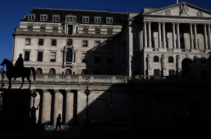 A person walks outside the Bank of England in the City of London financial district in London