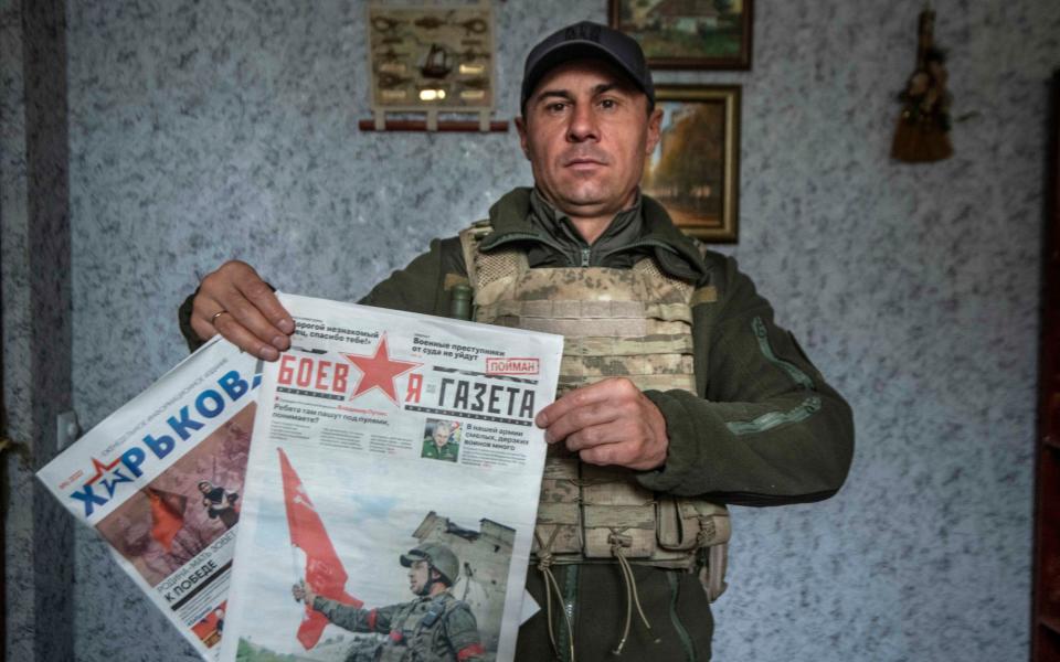 Vyacheslav Zadorenko with Russian newspapers that were distributed to the occupying soldiers and villagers - JULIAN SIMMONDS