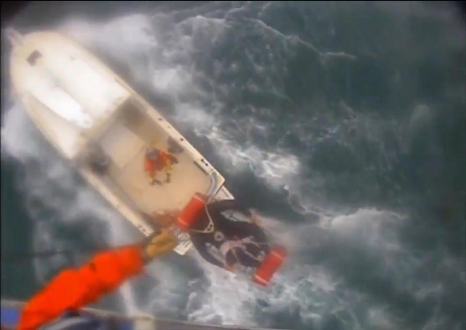 In this Saturday afternoon, Dec. 21, 2019, video image released by the U.S. Coast Guard shows a man, wearing a full-body wetsuit, being hoisted up from the boat into the helicopter near Santa Rosa Island, one of the Channel Islands in Southern California. A shark reportedly bit a surfer Saturday afternoon in a "truly terrifying situation," the Coast Guard said. The 37-year-old man had been surfing near Santa Rosa Island, one of the Channel Islands, during the attack, according to a news release. (U.S. Coast Guard Los Angeles via AP)