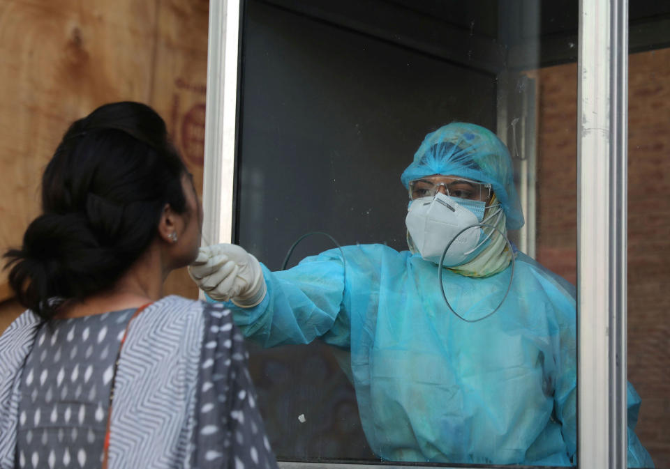 SRINAGAR, INDIA - AUGUST 10: A health worker collects a swab sample from a woman to test for coronavirus infection, at Tourist Reception Centre, on August 10, 2020 in Srinagar, India. (Photo by Waseem Andrabi/Hindustan Times via Getty Images)