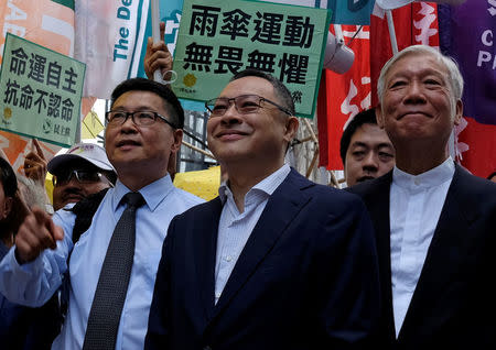 Occupy Central civil disobedience founders, professor of sociology Chan Kin-man, law professor Benny Tai and Reverend Chu Yiu-ming, protest outside a district court in Hong Kong September 19, 2017. REUTERS/Bobby Yip