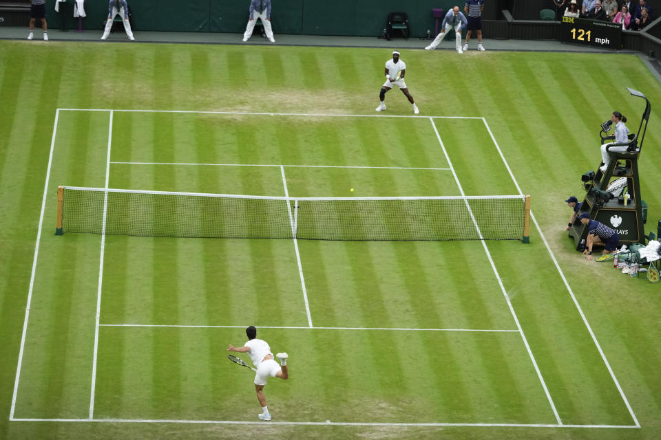 Spain's Carlos Alcaraz serves to Francis Tiafoe, top, of the United States during their third round match at the Wimbledon tennis championships in London, Friday, July 5, 2024. (AP Photo/Mosa'ab Elshamy)