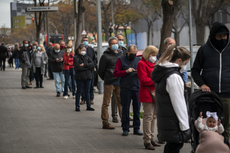 Decenas de personas hacen fila para recibir una dosis de la vacuna de AstraZeneca contra el COVID-19 el martes 6 de abril de 2021 en Barcelona, España. (AP Foto/Emilio Morenatti)