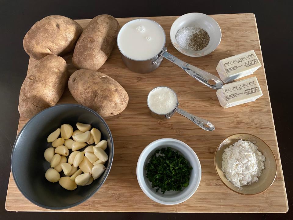 ingredients for julia child garlic mashed potatoes on a wooden cutting board