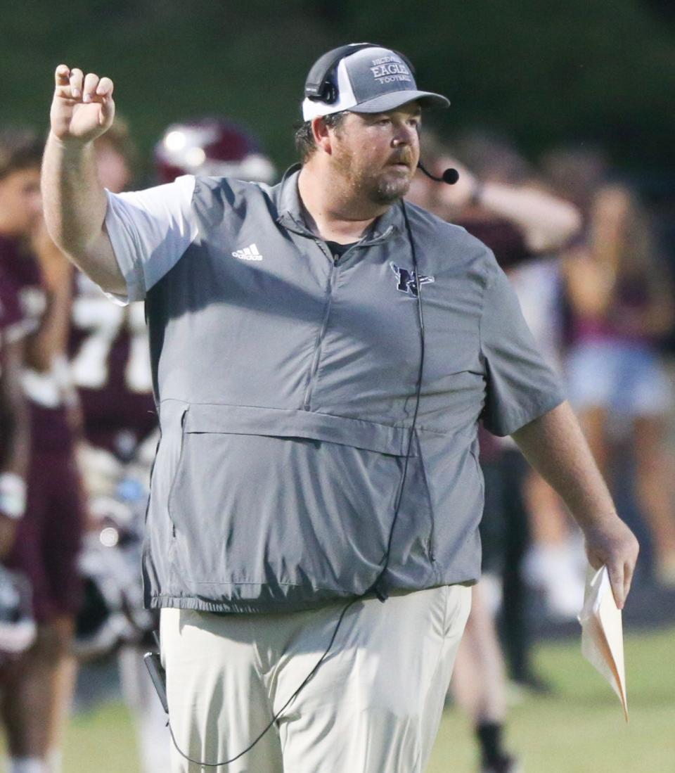 Eagles head coach Grant Thompson signals a play as Niceville hosts North Miami in the season home opener.