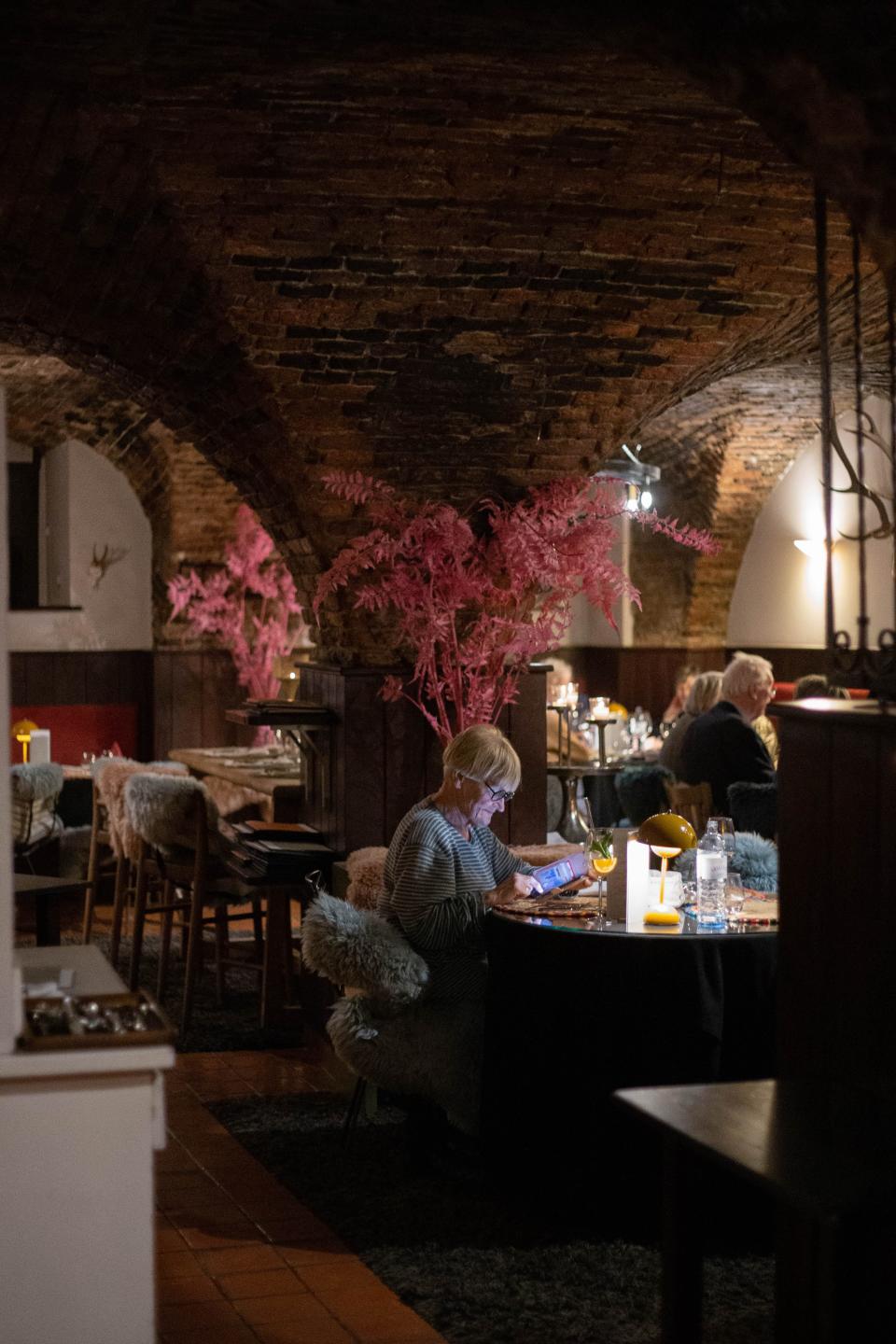 An old wine cellar with wooden tables and pink flowers