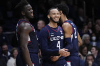 Connecticut guard Tyrese Martin, center, is congratulated by teammates Tyler Polley, right, and Adama Sanogo after being fouled in the second half of an NCAA college basketball game against Butler in Indianapolis, Thursday, Jan. 20, 2022. (AP Photo/AJ Mast)