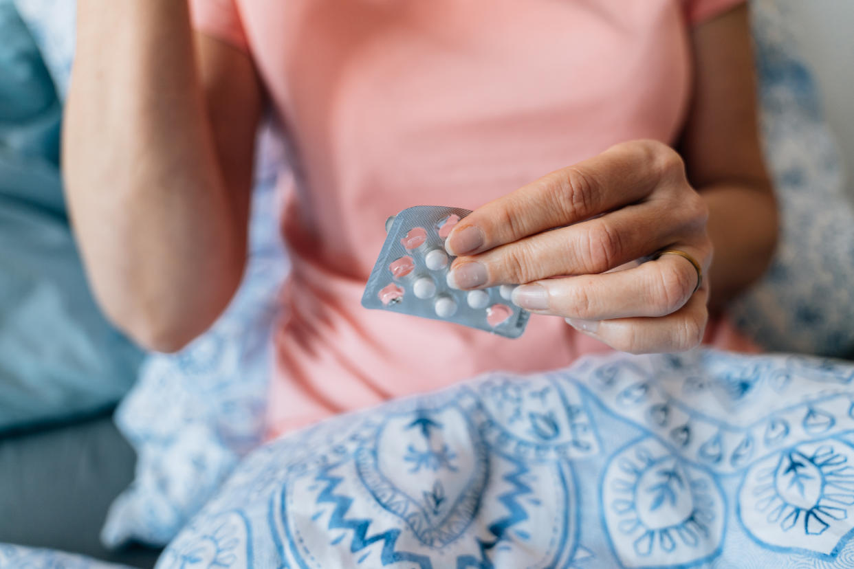 Close-up of woman hands with blister of pills. Hormone replacement therapy