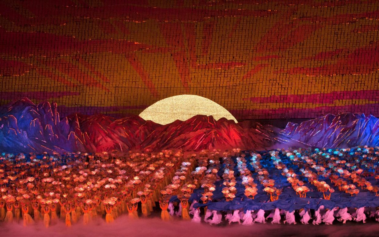 North Korean dancers in front of rising sun over mount Paektu made by children holding up boards during Arirang mass games - Corbis News