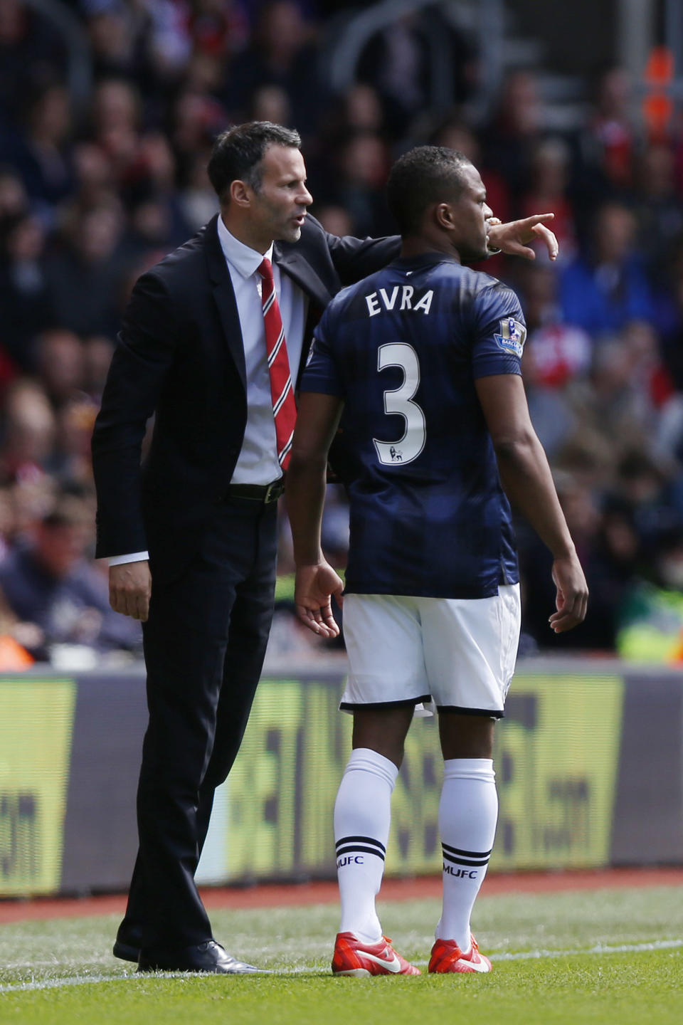 Manchester United's interim manager Ryan Giggs, left, instructs Patrice Evra during their English Premier League soccer match against Southampton at St Mary's stadium, Southampton, England, Sunday, May 11, 2014. (AP Photo/Sang Tan)