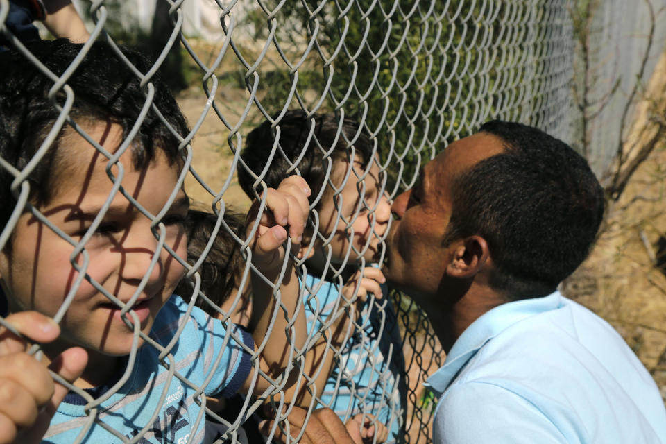 FILE - Ammar Hammasho, migrant from Edlib, Syria, who lives in Cyprus, kisses one of his four children after they arrived with their mother at a refugee camp in Kokkinotrimithia, outside the capital Nicosia, in the eastern Mediterranean island of Cyprus, on Sunday, Sept. 10, 2017. Cyprus has formally called on the European Union to re-evaluate which areas of Syria can be declared safe and free from armed conflict so that Syrian migrants can eventually be repatriated there, the Cypriot Interior Ministry said Friday, Sept. 22, 2023. (AP Photo/Petros Karadjias, File)