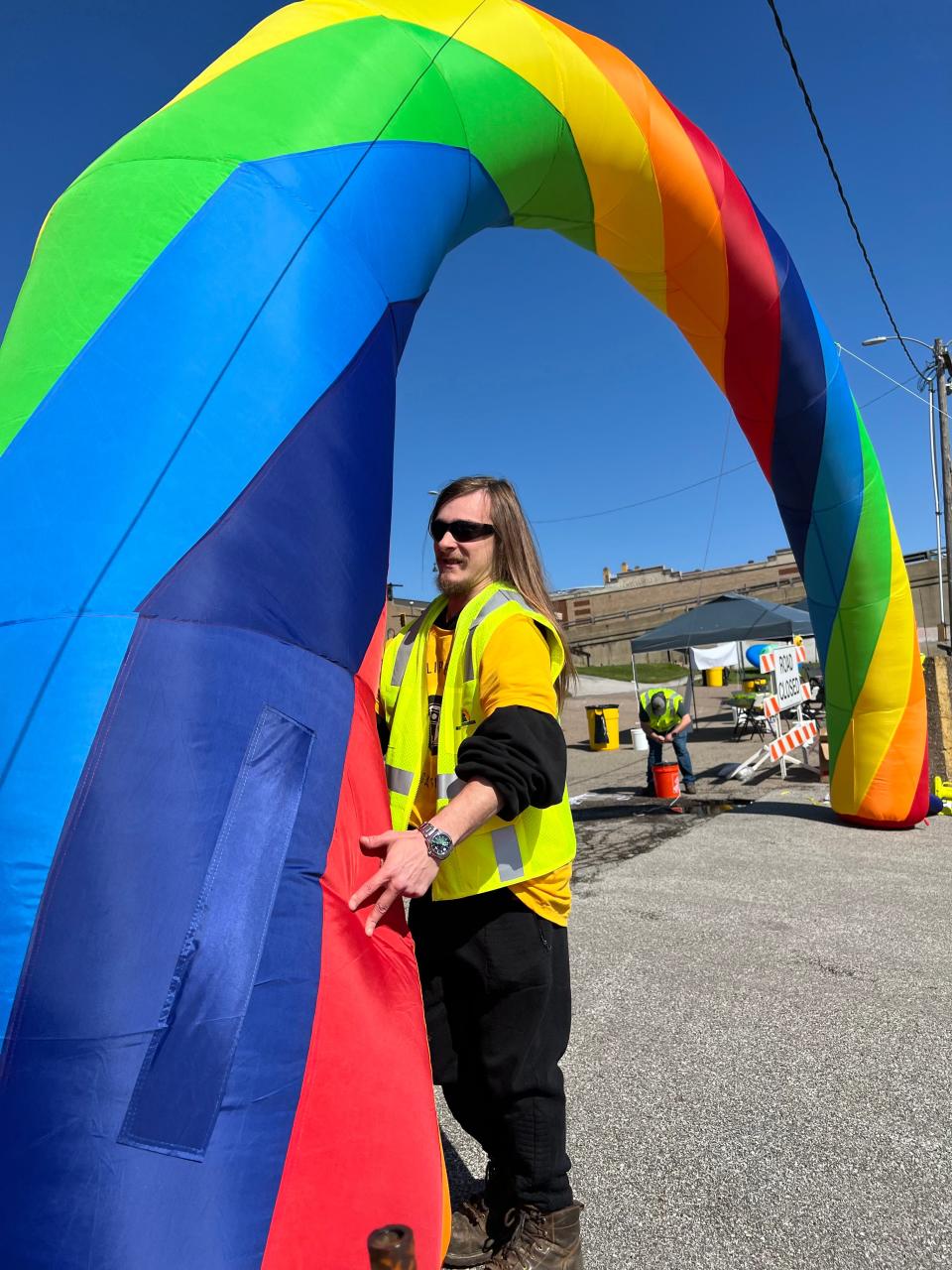 Jacob Smith, a worker from City of Cuyahoga Falls grounds maintenance, helps secure the entrance to EclipseFest 2024 on Front Street.