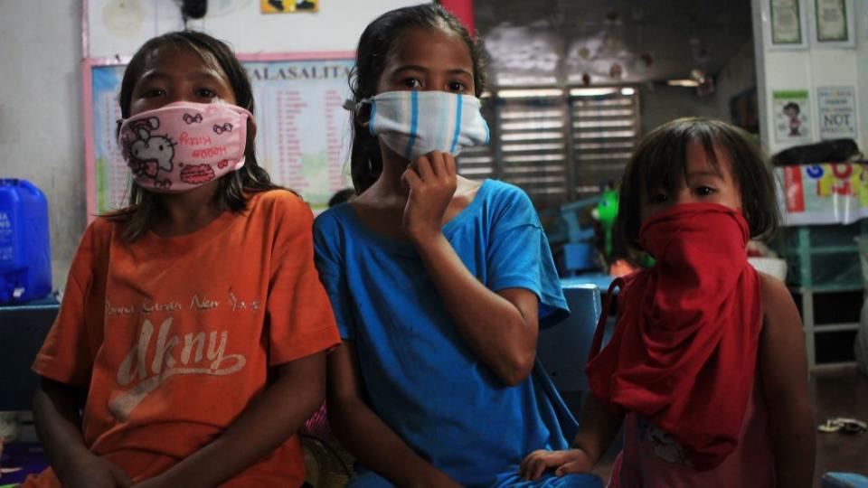 Children wearing improvised face masks take shelter at a school building serving as evacuation centre on May 14. Source: Getty