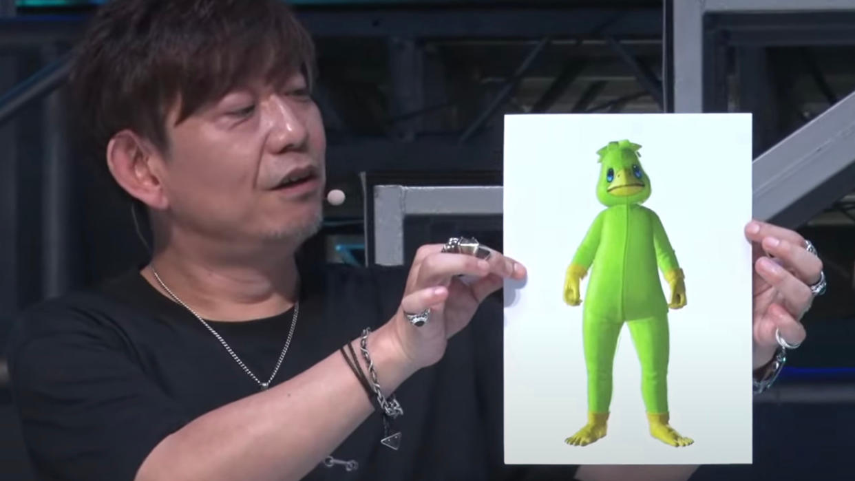  Final Fantasy 14's Naoki Yoshida holds up a picture of the MMO's upcoming kappa suit. 