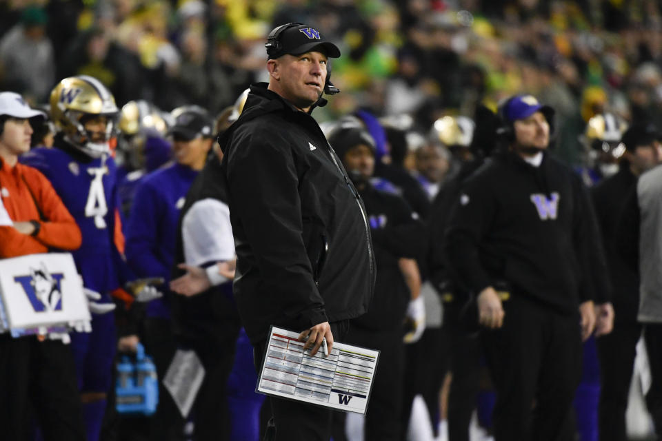 Washington head coach Kalen DeBoer, center, watches a replay during the first half of an NCAA college football game against Oregon, Saturday, Nov. 12, 2022, in Eugene, Ore. (AP Photo/Andy Nelson)