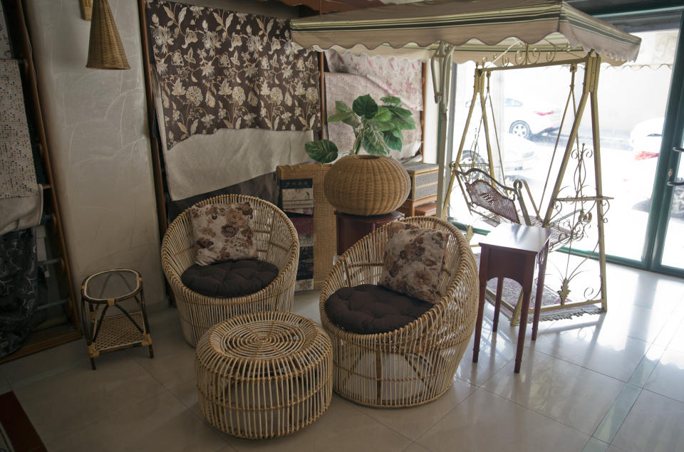 In this Saturday, July 6, 2019 photo, furniture for sale is displayed at a bamboo workshop in Gaza City.Talk about old Gaza, and what pops up are images of clay pottery, colorful glassware, bamboo furniture and ancient frame looms weaving bright rugs and mats. As such professions could be dying worldwide, the pace of their declining is too fast in Gaza that out of its some 500 looms, only one is still functioning. (AP Photo/Khalil Hamra)