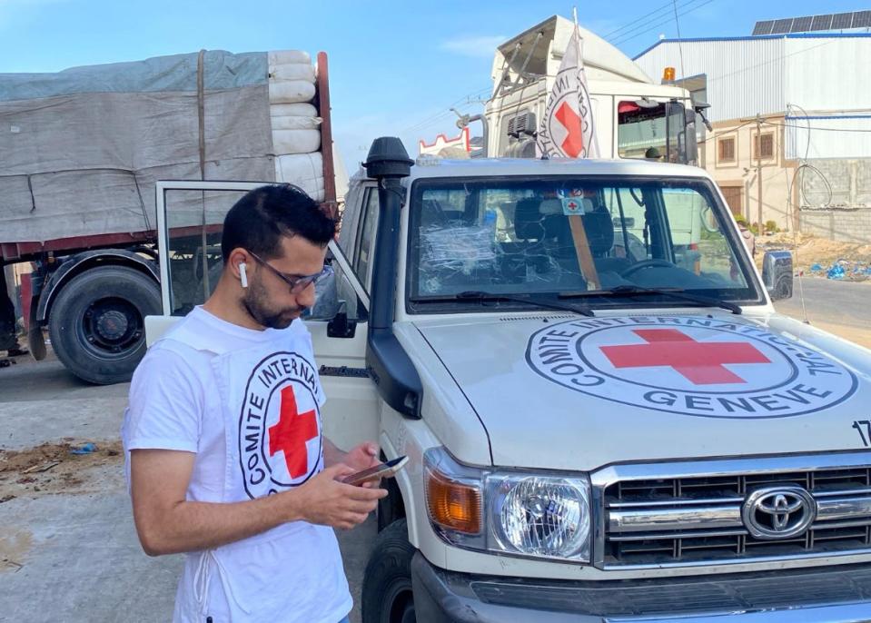 Hisham Mhanna is a communications employee for the International Committee of the Red Cross in Gaza. He is shown here standing by Red Cross trucks by the ICRC warehouse in southern Gaza.