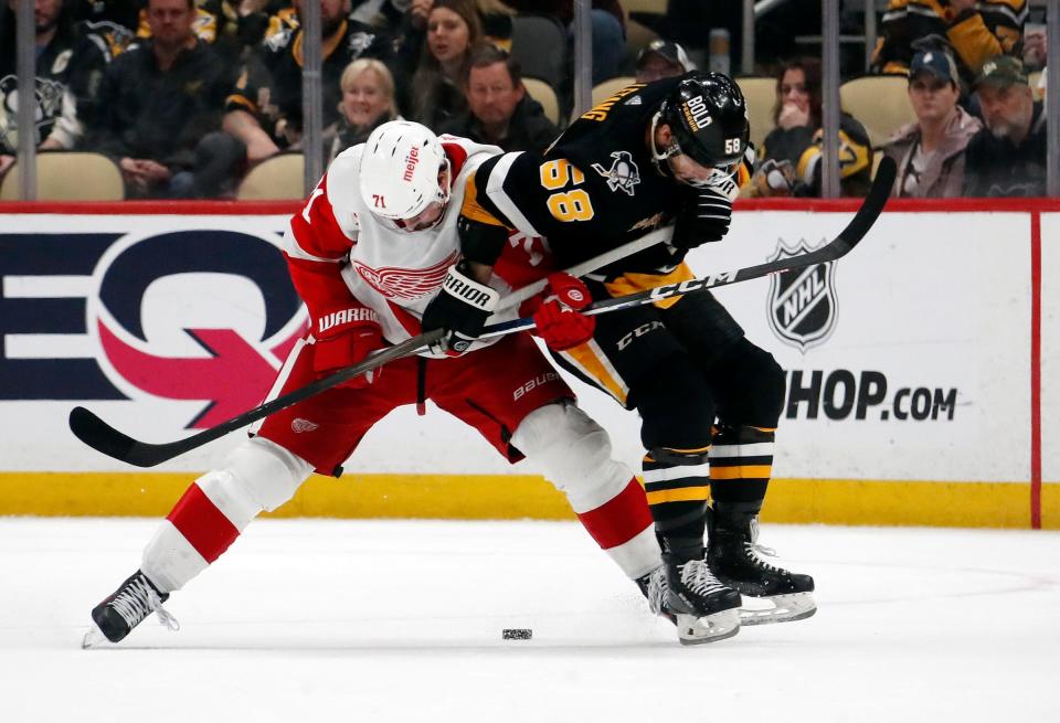 Red Wings center Dylan Larkin and Penguins defenseman Kris Letang battle for the puck in overtime of the Wings' 6-5 OT loss on Thursday, April 11, 2024, in Pittsburgh.