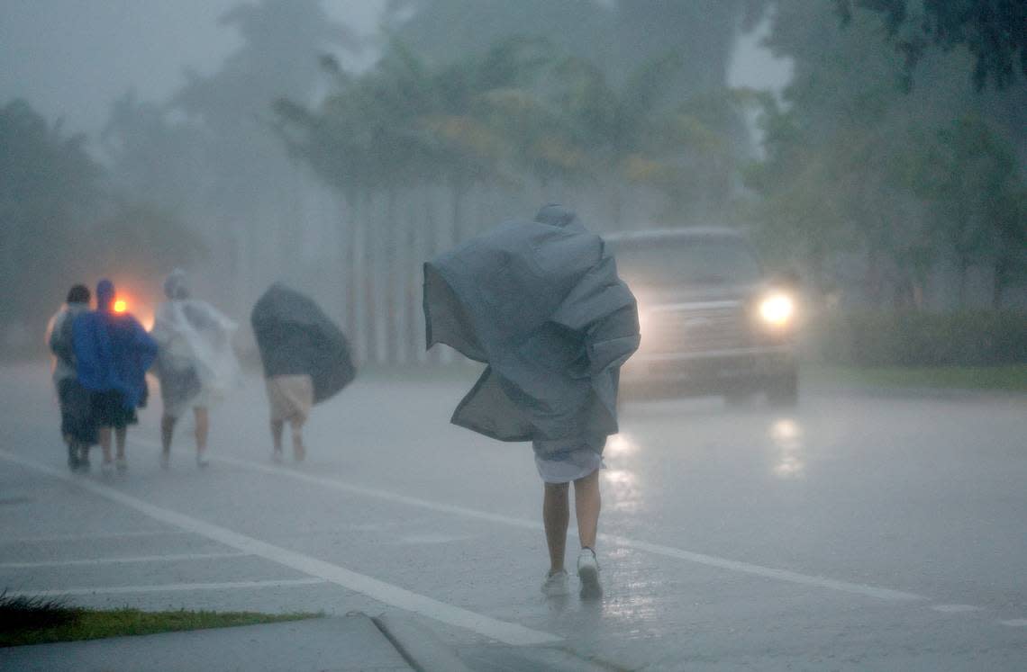 A group of people in raincoats walk east along Hollywood Boulevard in the pouring rain on Wednesday, April 12, 2023.