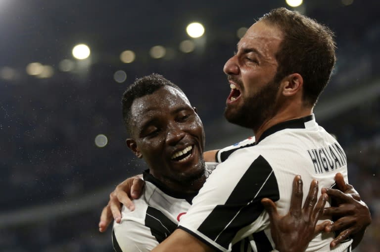 Juventus' forward Gonzalo Higuain (R) celebrates with his teammate Kwadwo Asamoah (L) after scoring a goal on August 20, 2016