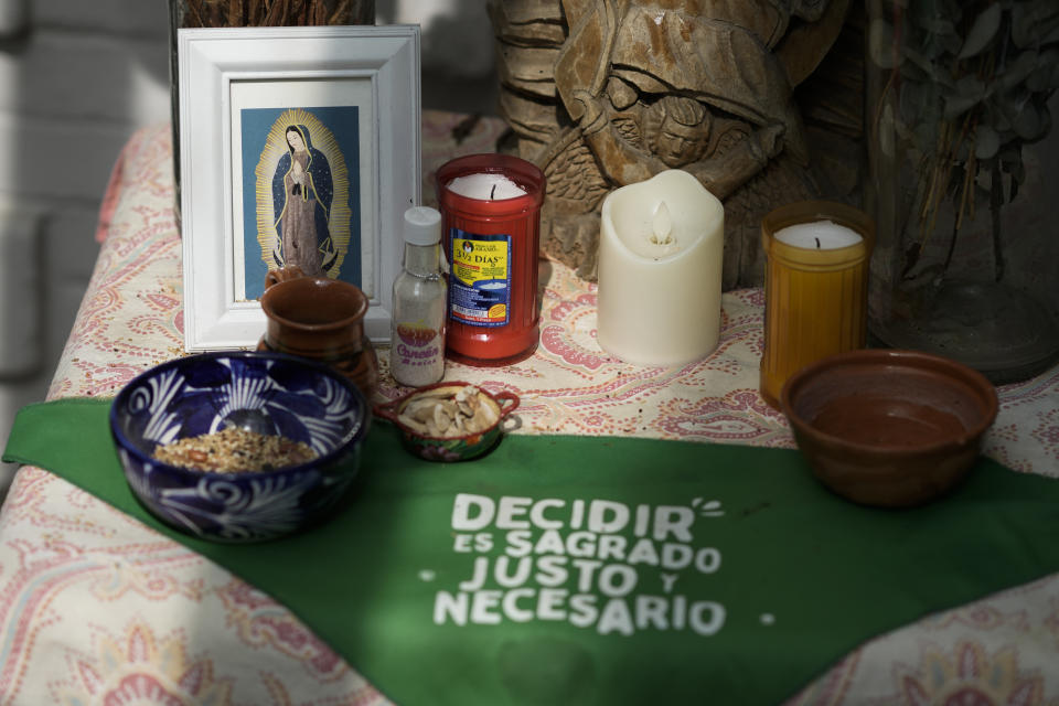 FILE - A green scarf with a message that reads in Spanish: "To decide is sacred, just and necessary" adorns an altar to Our Lady of Guadalupe, in the office of the Catholics for the Right to Decide, in Mexico City, Dec. 4, 2023. Members of the organization denounce the invisibility of women in some religious environments and advocate for the reinterpretation of sacred texts with a feminist perspective. (AP Photo/Eduardo Verdugo, File)