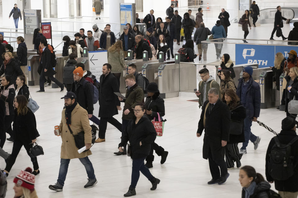 FILE - Commuters walk from the PATH rapid transit station into the World Trade Center in New York on Nov. 18, 2019. The pandemic’s Great Resignation has produced a Great Reinvention as more people of all ages have given up on jobs and find themselves pondering the work-life balance that lends meaning to their lives. (AP Photo/Mark Lennihan, File)