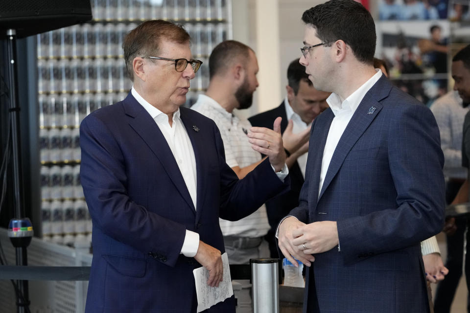 Miami Marlins owner Bruce Sherman, left, speaks with Peter Bendix, Miami Marlins president of baseball operations, right, before Bendix was introduced at news conference, Monday, Nov. 13, 2023, in Miami. (AP Photo/Lynne Sladky)