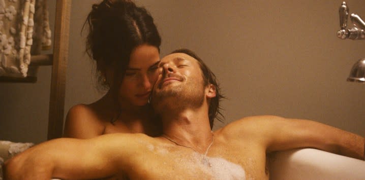 A man and a woman soak in a bathtub in Hit Man.