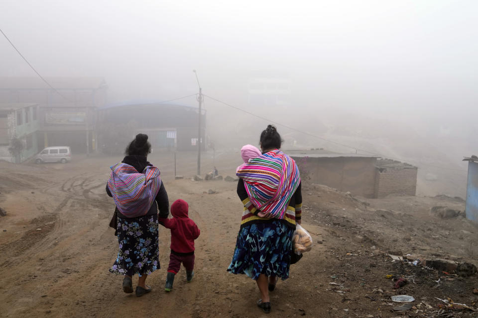 Residentes caminan en medio del frío y la espesa niebla en el barrio Ticlio Chico en las afueras de Lima, Perú, en el primer día oficial de invierno, el martes 21 de junio de 2022. Las temperaturas en la capital son las más bajas en 25 años, según el Servicio Nacional de Meteorología e Hidrología del Perú. (Foto AP/Martín Mejía)