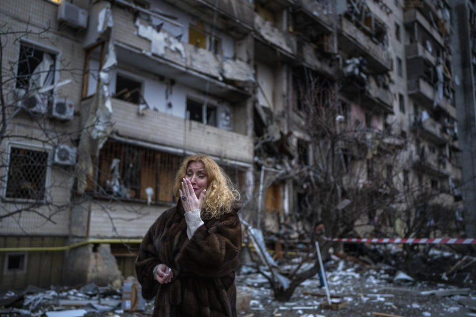 FILE - Natali Sevriukova reacts next to her house following a rocket attack the city of Kyiv, Ukraine, on Feb. 25, 2022. By ending 77 years of almost uninterrupted peace in Europe, war in Ukraine war has joined the dawn of the nuclear age and the birth of manned spaceflight as a watershed in history. After nearly a half-year of fighting, tens of thousands of dead and wounded on both sides, massive disruptions to supplies of energy, food and financial stability, the world is no longer as it was.(AP Photo/Emilio Morenatti)