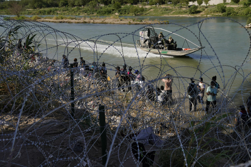 FILE - Migrants who crossed into the U.S. from Mexico are met with concertina wire along the Rio Grande, Sept. 21, 2023, in Eagle Pass, Texas. As Congress returns this week, Senate Republicans have made it clear they won’t support additional war aid for Ukraine unless they can pair it with border security measures. (AP Photo/Eric Gay, File)
