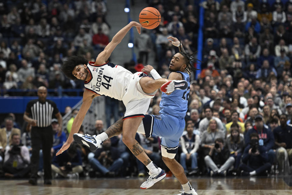 UConn's Andre Jackson Jr. (44) and Villanova's Cam Whitmore (22) collide when reaching for pass duriong the first half of an NCAA college basketball game Wednesday, Dec. 28, 2022, in Hartford, Conn. (AP Photo/Jessica Hill)