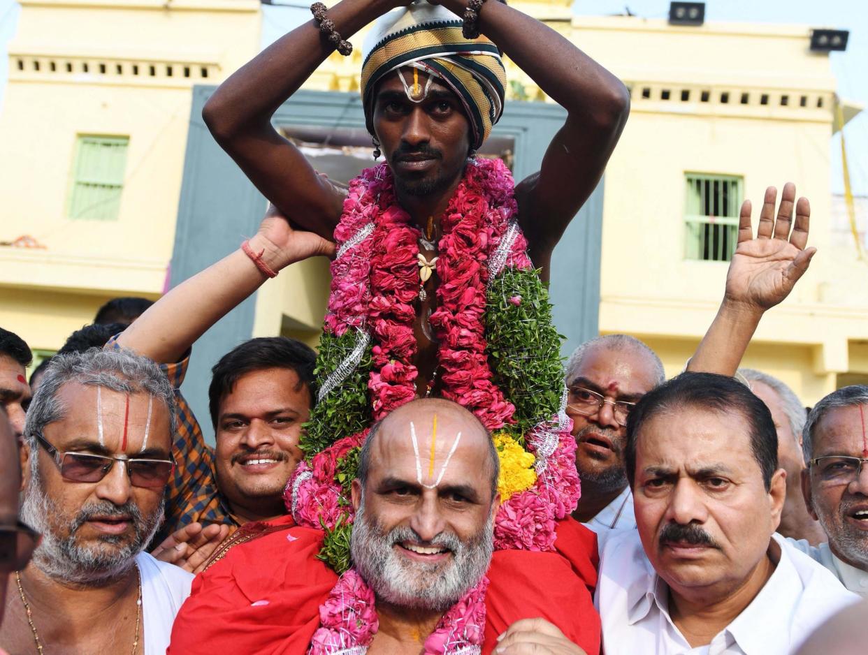 Hindu priest CS Rangarajan carries Dalit devotee Aditya Parasri on his shoulders (Getty)