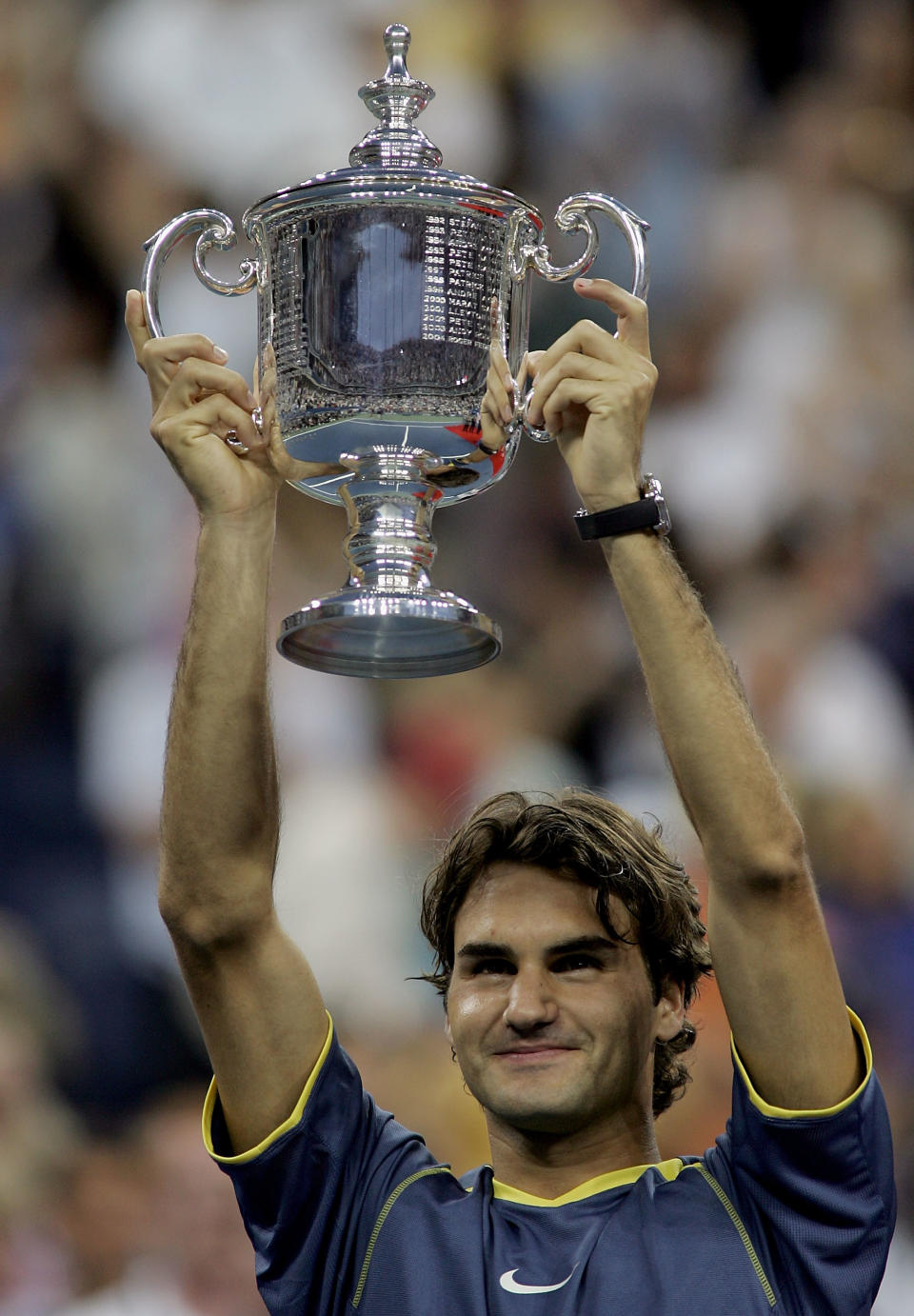 <p>Federer holds up the championship trophy after defeating Andre Agassi in 2005 </p>