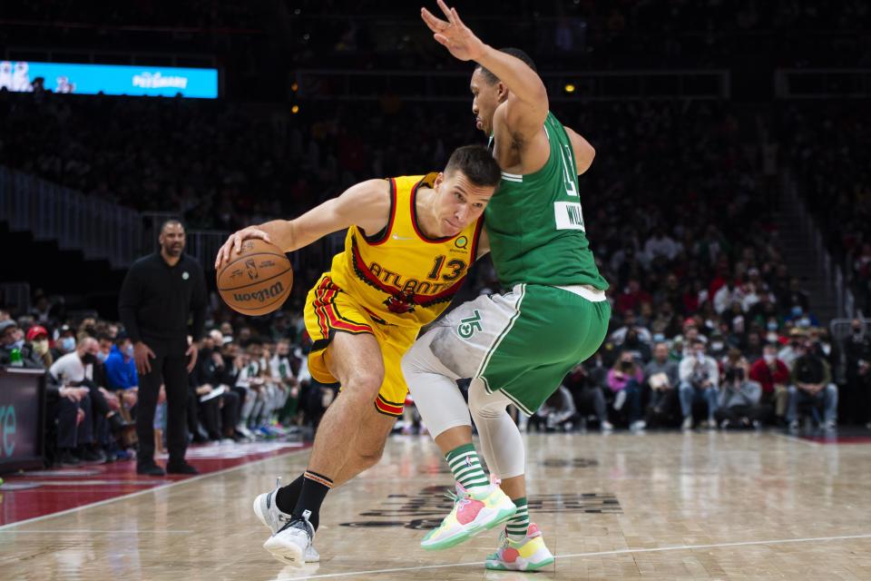 Atlanta Hawks guard Bogdan Bogdanovic (13) dribbles to the basket past Boston Celtics forward Grant Williams (12) during the second half of an NBA basketball game Friday, Jan. 28, 2022, in Atlanta. (AP Photo/Hakim Wright Sr.)