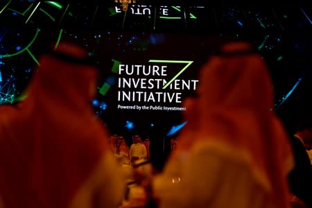 FILE PHOTO: Participants look at a sign of the Future Investment Initiative during the investment conference in Riyadh