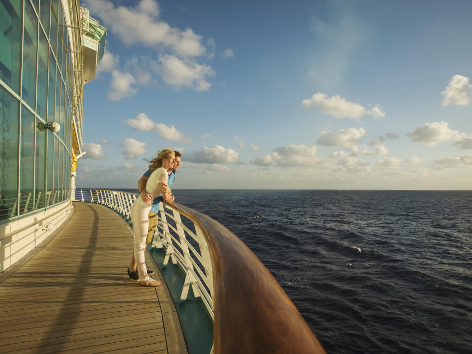 Couple admires the ocean view from the deck of a cruise ship. (Getty)