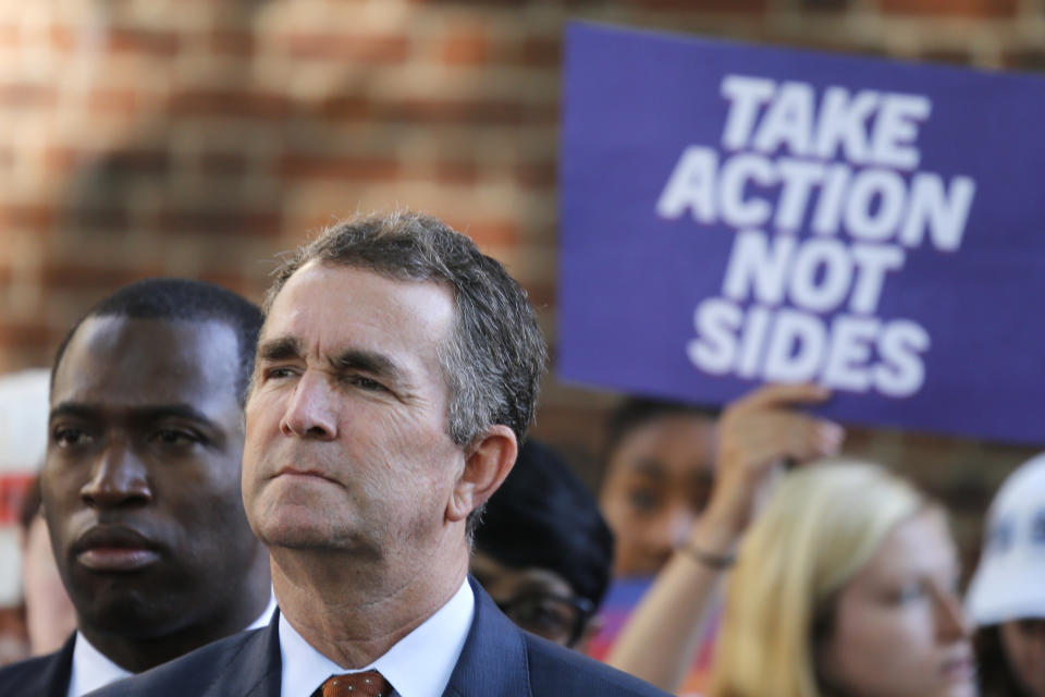 Virginia Gov. Ralph Northam, right, listens to speakers along with Richmond Mayor Levar Stoney, left, during a rally at the State Capitol in Richmond, Va., Tuesday, July 9, 2019. Governor Northam called a special session of the General Assembly to consider gun legislation in light of the Virginia Beach Shootings. (AP Photo/Steve Helber)