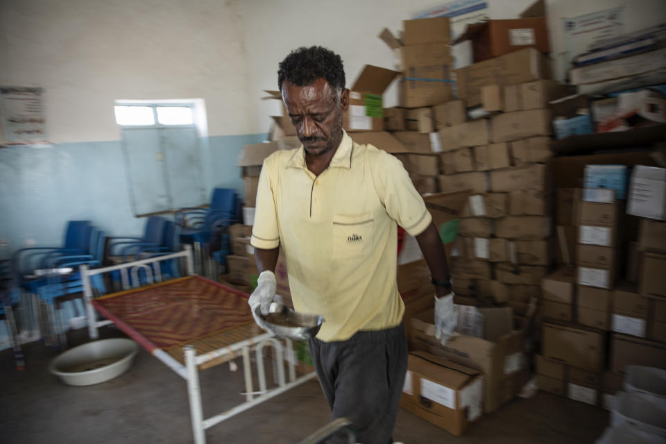 Surgeon and doctor-turned-refugee, Dr. Tewodros Tefera, sanitizes medical equipment, at the Sudanese Red Crescent clinic in Hamdayet, eastern Sudan, near the border with Ethiopia, on March 22, 2021. (AP Photo/Nariman El-Mofty)