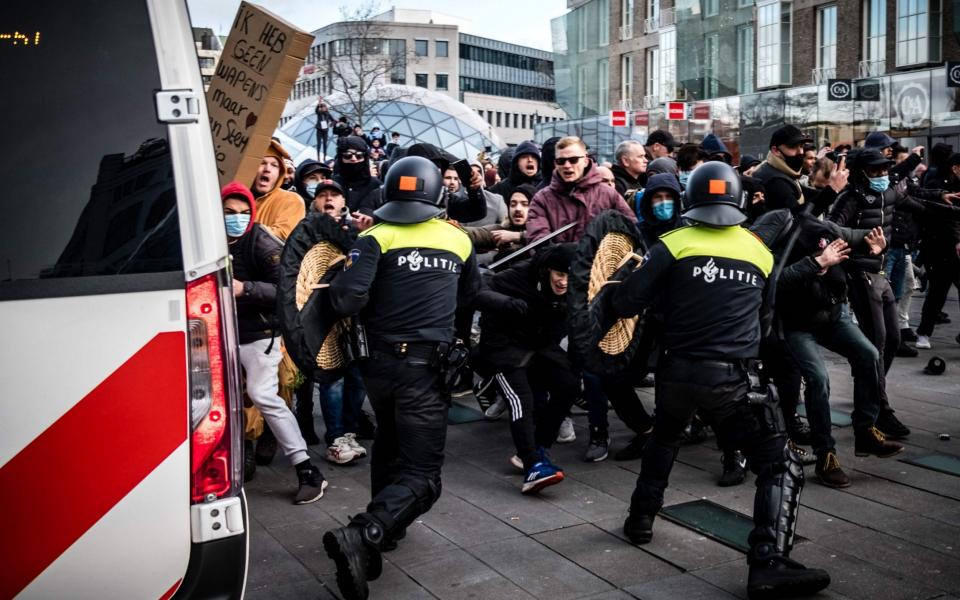 Protesters clash against Dutch anti-riot police officers during a demonstration against coronavirus restrictions in Eindhoven - AFP