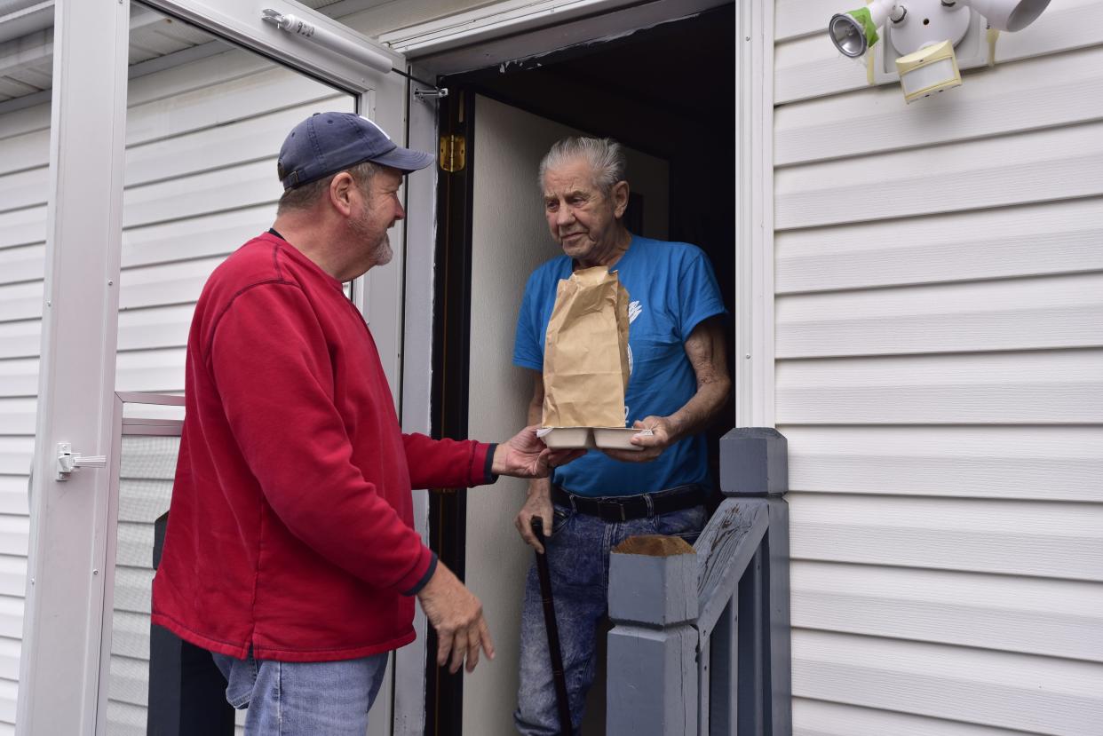 Dan Shelton delivers a pre-made meal to Marshall Smith on Wednesday, Nov. 16, 2022.