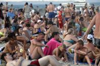People enjoy the beach in the Black Sea in Odessa, Ukraine, Sunday, July 5, 2020. Tens of thousands of vacation-goers in Russia and Ukraine have descended on Black Sea beaches, paying little attention to safety measures despite levels of contagion still remaining high in both countries. (AP Photo/Sergei Poliakov)