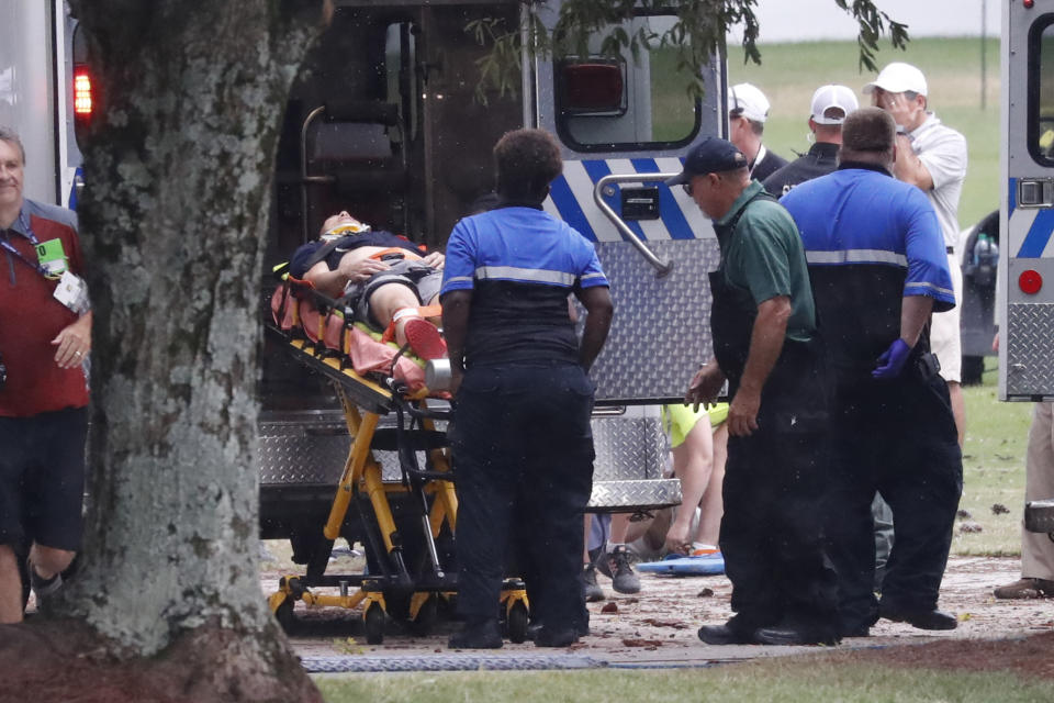 A injured golf fan is loaded into an ambulance after being struck lightning near the practice range during third round play in the Tour Championship golf tournament Saturday, Aug. 24, 2019, at East Lake Golf Club in Atlanta. (AP Photo/John Bazemore)
