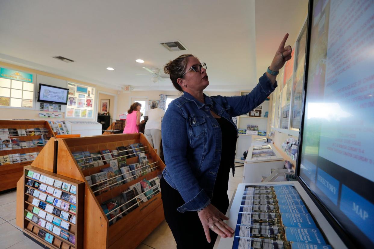 Donna Germain, president of the Cape Coral Chamber of Commerce, demonstrates the virtual board on display at the city's Welcome Center.