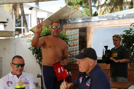 Swimmer Ben Hooper gestures as crew members eat breakfast on the morning before he begins a cross-Atlantic swim in Dakar, Senegal, November 13, 2016. Picture taken November 13, 2016. REUTERS/Emma Farge