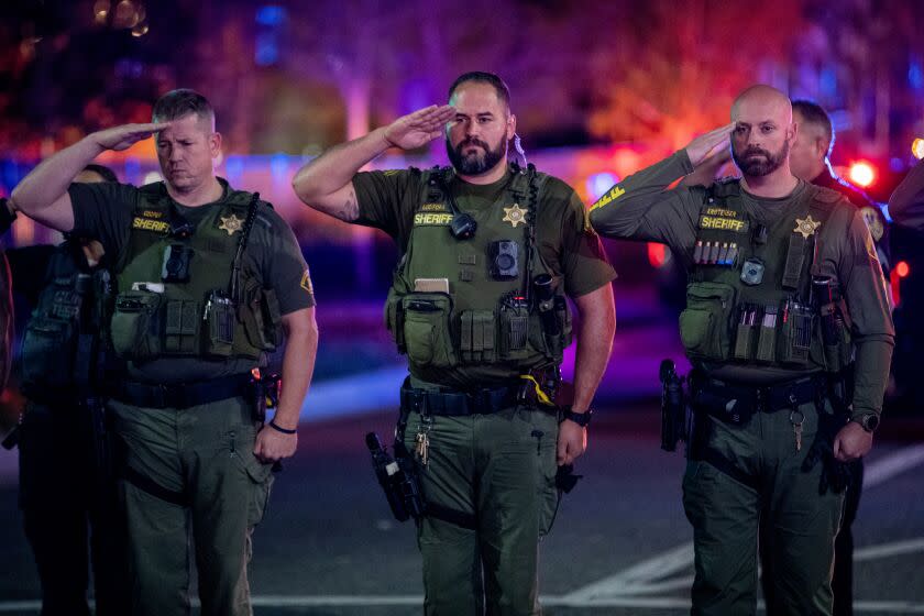 WILDOMAR, CA -JANUARY 13, 2023:Sheriff Deputies salute as the procession for fallen Riverside County Deputy Darnell Calhoun passes by as his body is taken away in hearse from Inland Valley Medical Center on January 13, 2023 in Wildomar, California. Calhoun was killed in the line of duty responding to a domestic violence call in Lake Elsinore Friday afternoon(Gina Ferazzi / Los Angeles Times)