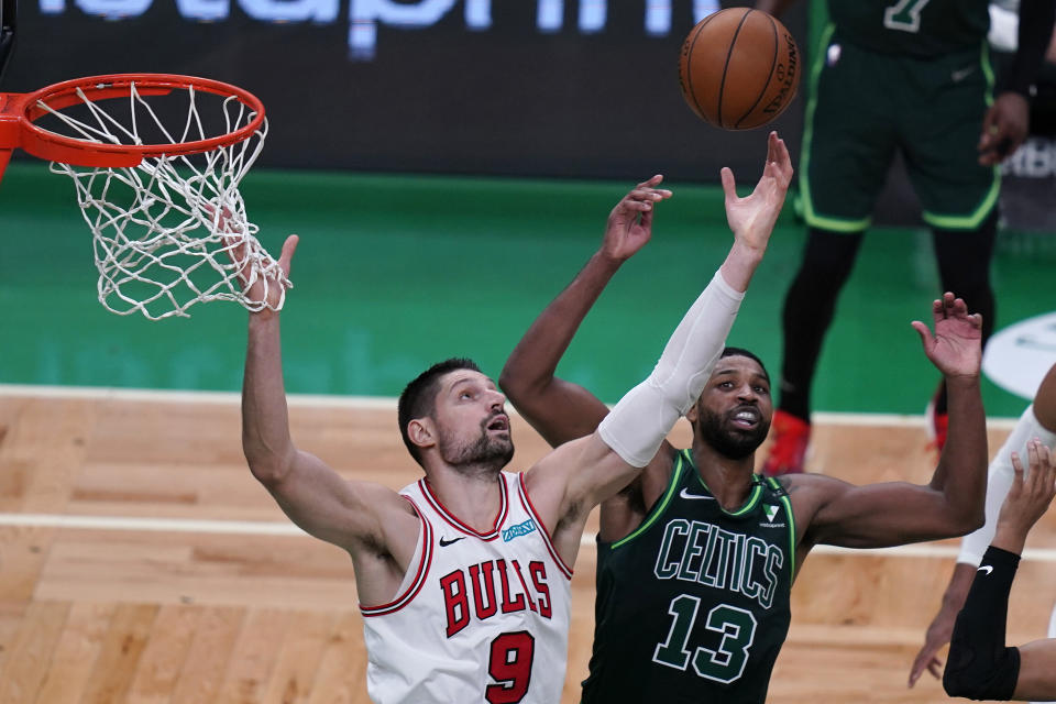 Chicago Bulls center Nikola Vucevic (9) reaches for a rebound against Boston Celtics center Tristan Thompson (13) during the second half of an NBA basketball game, Monday, April 19, 2021, in Boston. (AP Photo/Charles Krupa)