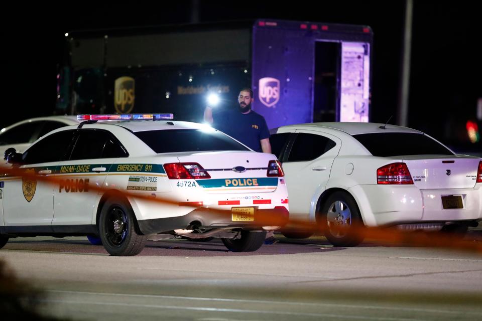 An FBI official investigates the scene of a shooting, Thursday, Dec. 5, 2019, in Miramar, Fla. Four people, including a UPS driver, were killed Thursday after robbers stole the driver’s truck and led police on a chase that ended in gunfire at a busy Florida intersection during rush hour, the FBI said.