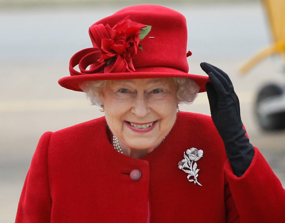 HOLYHEAD, UNITED KINGDOM - APRIL 01:  Queen Elizabeth II holds on to her hat in high winds during a visit to RAF Valley where Prince William is stationed as a search and rescue helicopter pilot on April 1, 2011 in Holyhead, United Kingdom. The Queen toured the airbase meeting staff and families, watched a fly past and was given a guided tour of a Sea King search and rescue helicopter by Prince William.  (Photo by Christopher Furlong-WPA-Pool/Getty Images)