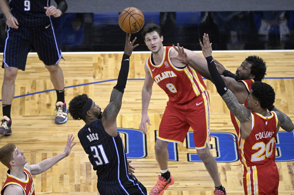 Orlando Magic guard Terrence Ross (31) shoots in the final seconds as Atlanta Hawks guard Kevin Huerter, left, forward Danilo Gallinari (8), forward Solomon Hill and forward John Collins (20) defend during the second half of an NBA basketball game Wednesday, March 3, 2021, in Orlando, Fla. (AP Photo/Phelan M. Ebenhack)